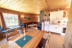 a dining room and kitchen in a log cabin at Jotunheimen Feriesenter in Heidal