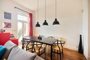 een eetkamer met een zwarte tafel en stoelen bij The Clapham Crib - Spacious 4BDR House with Patio in Londen