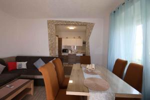 a living room with a table and a couch at Apartment in Silo - Insel Krk 13554 in Šilo