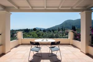 un patio con tavolo e sedie su un balcone di Private Corfu Villa 3 Bedrooms Villa Aziza Great Pool And Outdoor Area a Vouniatádes