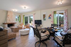 un ampio soggiorno con tavolo e sedie di Private Corfu Villa 3 Bedrooms Villa Aziza Great Pool And Outdoor Area a Vouniatádes