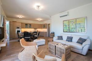 un soggiorno con un divano bianco e sedie di Private Corfu Villa 3 Bedrooms Villa Aziza Great Pool And Outdoor Area a Vouniatádes