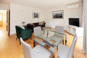 een woonkamer met een glazen tafel en stoelen bij The Bayswater Nook - Stylish 1BDR Flat in Londen