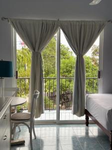 a bedroom with a bed and a sliding glass door at Hotel Naturaleza Bacalar- Gratis bicibletas in Bacalar