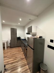 a kitchen with a stainless steel refrigerator and wooden floors at Le fayet in La Celle-sous-Gouzon +10 photos