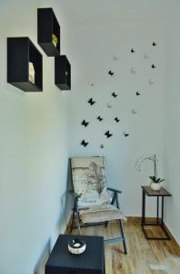 Apartment Lorena -prizemlje,EG,pianterreno في رييكا: غرفة بها كرسي وخفافيش على الحائط