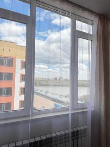 a window with a view of a building at Апартаменты по суточно in Zhezdi