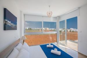 ein Wohnzimmer mit Couch und großem Fenster in der Unterkunft Villa Manta Platina - Brand New Luxury 3 Bedroom Protaras Villa in Protaras