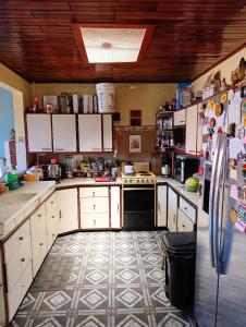 a kitchen with a refrigerator and a tile floor at The Cozy Cactus House B&B Cartago Centro English Spoken in Cartago