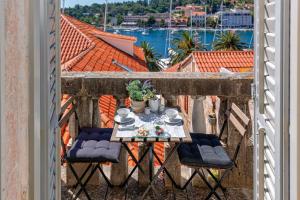 a table and chairs on a balcony with a view at Villa Hvar Royale - 5 Bedroom Central Villa - Indoor Pool - Beautiful Heritage Villa in Hvar