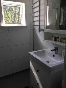 un bagno bianco con un lavandino e una finestra di Nice cottage in the Stockholm Archipelago a Utö