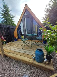 a tiny house with a picnic table on a deck at Corby cabin in Ardara