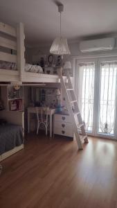 a bedroom with a bunk bed with a desk and a ladder at A casa di Alessia in Santa Maria delle Mole