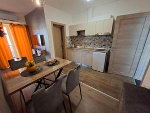 a kitchen with a table and chairs in a room at Apartman Jasmin in Bukorovac