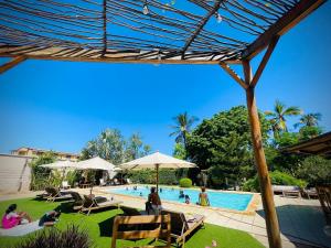 a group of people sitting around a swimming pool at CHEZ ALAIN in Toliara