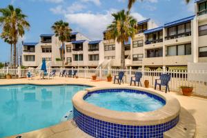 a swimming pool with chairs and a building at Swim, Fish and Suntan Cozy Corpus Christi Retreat in Corpus Christi