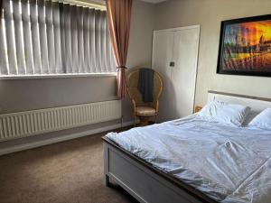 a bedroom with a bed and a chair and a window at The Fell in Sacriston