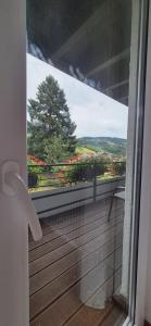 a balcony with a view of a tree and flowers at Renatas Ferienwohnung Maria in Sasbachwalden