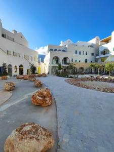 a building with large rocks in a courtyard at Melina Rooms in Dhërmi