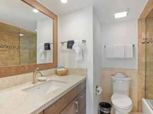 a bathroom with a sink and a toilet and a mirror at Lift One Condominiums - 1, 2, 3 Bedroom Units Adjacent To Downtown Aspen in Aspen