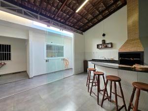 a kitchen with bar stools and a large window at 2 quartos ao lado Gin Costa Cavalcanti 10 m centro in Foz do Iguaçu