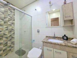 a bathroom with a shower and a toilet and a sink at 2 quartos ao lado Gin Costa Cavalcanti 10 m centro in Foz do Iguaçu +32 photos