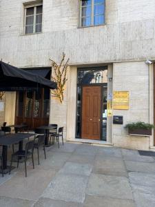 Unas mesas y sillas delante de un edificio. en Dolce sogno appartment, en Turín