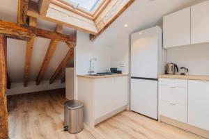 a kitchen with white cabinets and a vaulted ceiling at Fomento by Wynwood House in Madrid +281 photos