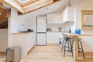a kitchen with white cabinets and a wooden table at Fomento by Wynwood House in Madrid