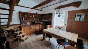 a kitchen with a wooden table and chairs in a room at Gospodarstwo agroturystyczne Ryznerówka in Posada Rybotycka