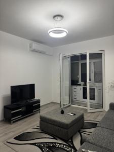 a living room with a couch and a flat screen tv at Mira's Apartment in Shkodër