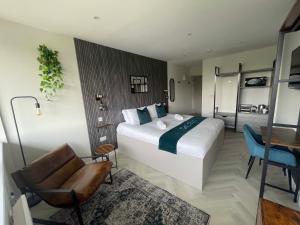 a bedroom with a large white bed and a chair at CoStays Aparthotel - Middlesbrough in Middlesbrough
