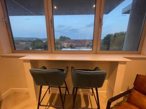 two chairs sitting at a bar in front of a window at CoStays Aparthotel - Middlesbrough in Middlesbrough