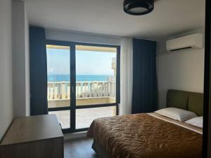 a bedroom with a bed and a large window at Sea View Luxury Apartment in Bŭnzareto