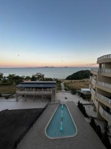 a swimming pool next to a building and the ocean at Sea View Luxury Apartment in Bŭnzareto