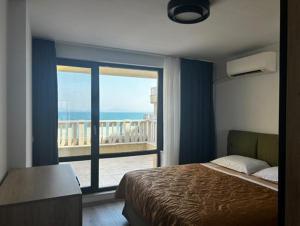a bedroom with a bed and a view of the ocean at Sea View Luxury Apartment in Bŭnzareto +9 photos