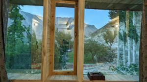 a room with a window with a view of mountains at MUD ROOMS by MANOKUR- E- BASA in Minapin