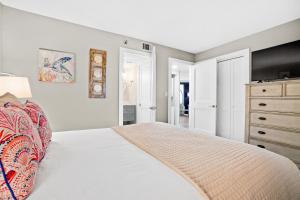 ein weißes Schlafzimmer mit einem Bett und einer Kommode in der Unterkunft Another Day in Paradise Beachfront Bliss Remodeled Luxury Sandestin® Escape in Destin + 34 Fotos