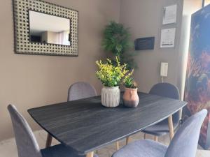 a dining room table with chairs and a mirror at 3 bedroom apartment, with arcade machine - 1 block from lleras park p7 in Medellín +14 photos