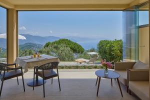 a living room with a table and chairs and a large window at Il Leccio - Luxury Resort Portofino Monte in Santa Margherita Ligure
