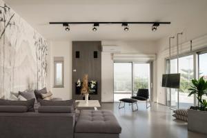 a living room with a couch and a tv at Extravagant Crete Villa 4 Bedrooms Villa Yasemí I Private Pool And Outdoor Amenities Bbq Rethymno in Prínos