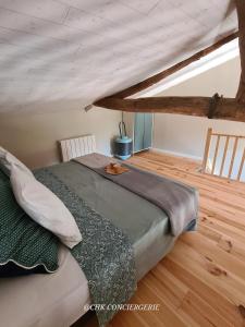 ein großes Bett in einem Zimmer mit Dachgeschoss in der Unterkunft Cottage Authentique avec Mezzanine proche du Puy duFou in LʼÉpaux