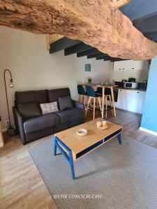 ein Wohnzimmer mit Sofa und Tisch in der Unterkunft Cottage Authentique avec Mezzanine proche du Puy duFou in LʼÉpaux + 36 Fotos