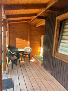 a wooden deck with a table and chairs on it at Letnisko na Pierkunowie in Giżycko