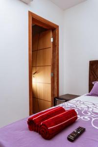 una valigia rossa appoggiata su un letto con un telecomando di Hospedagem de Luxo São Lourenço a São Lourenço Altre 12 foto