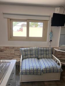a couch in a living room with a window at Sandy Nest Studio in Larnaka