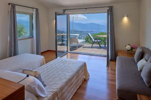 a room with two beds and a couch and a balcony at Il Leccio - Luxury Resort Portofino Monte in Santa Margherita Ligure