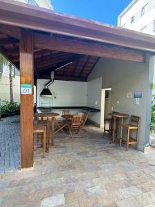 a pavilion with wooden tables and chairs on a patio at Almaré Home in Ubatuba