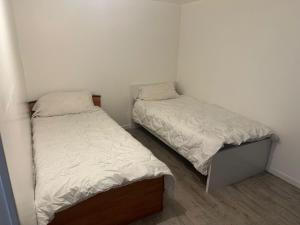 two beds in a small room with white walls at Studio Argenteuil in Argenteuil