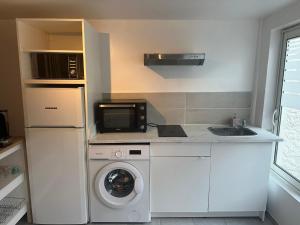 a kitchen with a washing machine and a microwave at Studio Argenteuil in Argenteuil